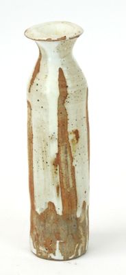 a brown and white vase sitting on a white surface