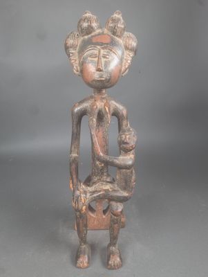 un gros plan sur la statue d'une femme tenant un bébé dans ses bras