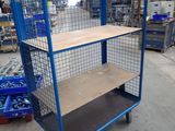 a blue cart with a shelf on it in a warehouse