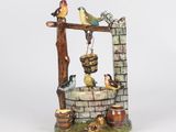 a figurine of a well with birds on it