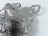 a silver figurine that is sitting on a table