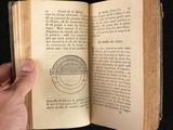 someone is holding a book open with a drawing of a circle on it