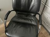 a black leather office chair in the corner of a room