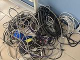 a pile of wires on the floor next to a refrigerator