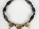 a close up of a necklace made of wooden beads and black beads