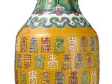 un vase jaune orné d'inscriptions asiatiques sur fond blanc