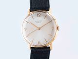 a close up of a watch on a black leather strap