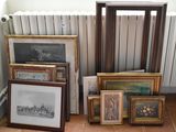a lot of framed pictures on the floor next to a radiator