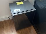 an image of a small black refrigerator in a room