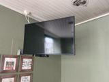 une télévision à écran plat fixée au mur au-dessus d'un lit