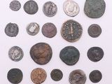 une image représentant une collection de pièces de monnaie romaines antiques posées sur une surface blanche
