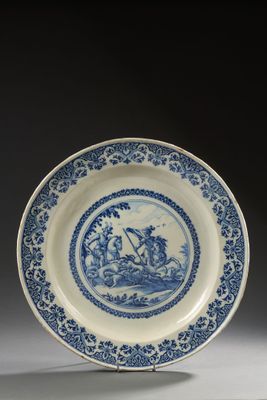 an image of a blue and white plate with a picture of a man on a boat