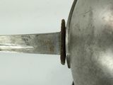 a silver spoon with a metal handle on a white surface