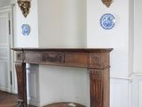 a fireplace in the middle of a room with a clock on the wall