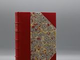 un livre rouge avec un motif floral sur la couverture