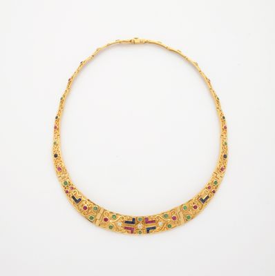 un collier en or orné de pierres multicolores sur fond blanc