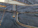 the back of a pair of blue jeans with orange stitching on them
