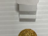 gros plan d'une pièce d'or sur une surface blanche