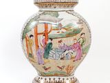 a vase with a painting on it sitting on a table
