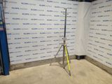 a tripod in front of a wall with a sign on it