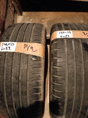 two tires with labels on them are sitting on the floor