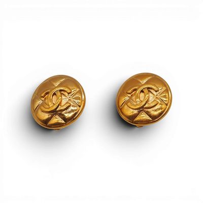 une paire de boucles d'oreilles plaquées or, ornées d'un motif représentant un oiseau et une fleur