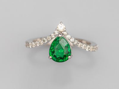 une bague sertie d'une émeraude en forme de poire et de diamants