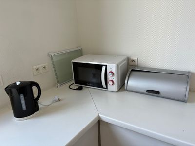 un micro-ondes et un grille-pain posés sur le plan de travail de la cuisine