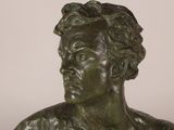 a close up of a bronze statue of a man with curly hair