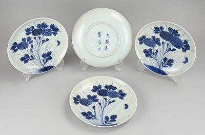 trois assiettes bleues et blanches ornées de fleurs, posées sur une table