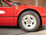 a red sports car parked in front of a brick wall