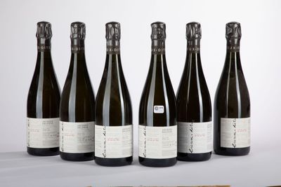 six bottles of wine sitting on a table next to a bottle of wine