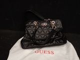 un sac à main noir matelassé posé sur un sac blanc, sur un fond noir
