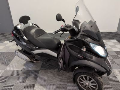 a scooter that is parked on a checkered floor