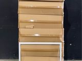 une pile de cartons posée sur une palette devant un mur noir