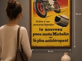 une femme debout devant une affiche accrochée au mur