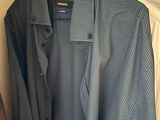 shirt hanging on a hanger in a closet next to a pile of clothes