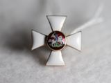 une petite croix blanche ornée d'une fleur rouge et verte