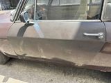 a dirty car parked on the side of the street