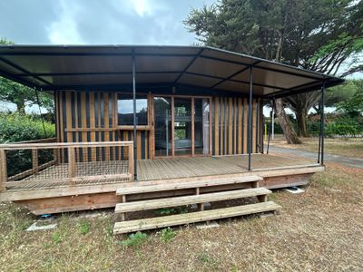 a small wooden cabin with a metal roof on the grass