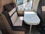 a small table and a chair in the back of a camper
