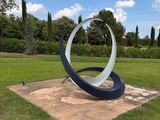 a sculpture in the middle of a grassy field