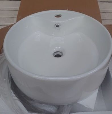 un évier blanc posé sur une boîte en carton