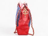 red and blue handbag with gold chain strap on a white background