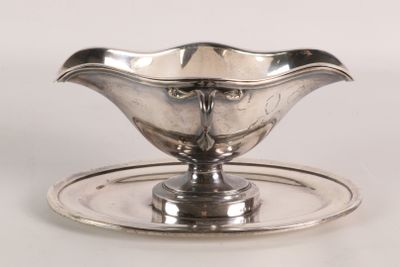 a silver plate with a silver saucer on it