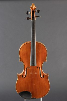 an old violin on a stand against a gray background