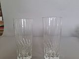 two glasses sitting on a table next to each other