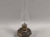 une lampe à huile à l'ancienne posée sur une table blanche