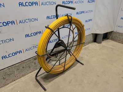 a yellow hose on the ground next to a wall