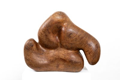 a wooden sculpture that is on a white surface